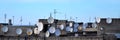 A lot of satellite television antennas on the rooftop under a bl Royalty Free Stock Photo