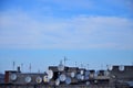 A lot of satellite television antennas on the rooftop under a bl Royalty Free Stock Photo