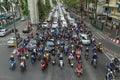 Many scooters and cars on a road in Bangkok