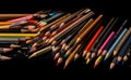 a lot of sharpened colored pencils on a black background with space for text