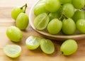 A lot of Shine-Muscat grapes and cut Shine-Muscat grapes on a wooden background