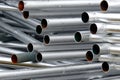 A lot of silver iron pipes piled up.