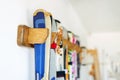 Lot of ski hanged on customized wooden wall mount at garage for seasonal storage. Extreme winter sport equipment handling at home