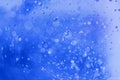 Lot of small bubbles on an blue background, macro shot of liquid soap, macro shot of glass with beer, macro shot of cocktail with Royalty Free Stock Photo