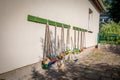 Lot of small coloured brooms hang on the outside wall of a kindergarten