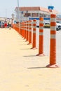 Lot of striped orange reflictive traffic bollards placed in row for safety and security between roads and pedestrian