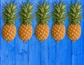 A lot of succulent pineapples on the blue wooden table. Healthy dietary food Royalty Free Stock Photo