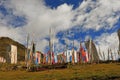 A lot of Tibetan prayer flags flying wiht Mandala on the hillside