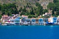 A lot of tiny colorful houses on the rocky shore of Mediterrenean sea on Simy greek island in sunny summer day,