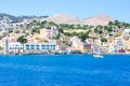 A lot of tiny colorful houses on the rocky shore of Mediterrenean sea on Simy greek island in sunny summer day, tourism on exotic