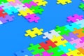 Lot of unfinished colorful puzzle jiggle pieces on blue background