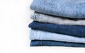 Lot of used different jeans stacked in a pile isolated on white background Royalty Free Stock Photo