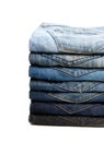 Lot of used jeans stacked in a pile isolated on white Royalty Free Stock Photo