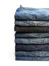 Lot of various used unisex jeans stacked in a pile isolated on white Royalty Free Stock Photo