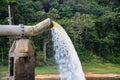 Lot of water gushing out of the big metal pipe to the lake, pump water fill in reservoir Royalty Free Stock Photo