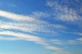 A lot of white clouds of different types: cumulus, cirrus, layered high in blue sky