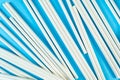 A lot of white paper tubes are scattered randomly on a blue background. The view cocktail tube texture. Zero waste