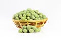 Lot of whole spicy green wasabi peanut in dark ceramic bowl isolated on white background