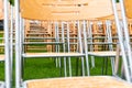 Wooden chairs stand outside in the park in the rain. Empty auditorium, green grass, waterdrops, closeup Royalty Free Stock Photo