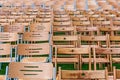 Wooden chairs stand outside in the park in the rain. Empty auditorium, green grass, waterdrops, closeup Royalty Free Stock Photo