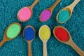 Set of wooden spoons with colored powder on a blue background Royalty Free Stock Photo