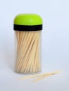 A lot of wooden toothpicks in a transparent plastic jar with a black and green lid on a neutral background, closeup Royalty Free Stock Photo