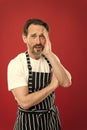 Lot of work. Confident mature handsome man in apron red background. He might be baker gardener chef or cleaner. Good in Royalty Free Stock Photo