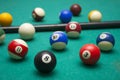Lots of billiards and the cue on the billiard table, sports and recreation. Focused on the eight ball