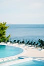 Lots of black sunbeds near the swimming pool, in a hotel near the sea. Royalty Free Stock Photo