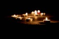 Lots of candle lights, glowing against a dark background. Candles path in the dark