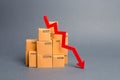 Lots of cardboard boxes and a red arrow down. Concept drop in industrial production, sales fall. economic downturn