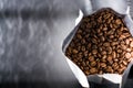 Lots of coffee beans in a bag on dark background. Arabica. Coffee shop.