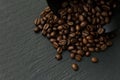 Lots of coffee beans in a Cup on a black textured background of slate stone Royalty Free Stock Photo