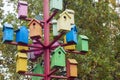 Lots of colorful nesting boxes. Many bright colored birdhouses