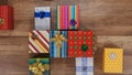 Lots of colorful wrapped presents gather on wooden surface