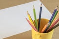 A lots of colour pencil in yellow cup and white paper on background , prepare drawing