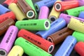 Lots of cylindrical multi-colored 18650 lithium-ion batteries are scattered on the table. Li-ion high current