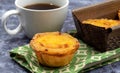 Lots of desserts Pastel de nata or Portuguese egg tart with a white cup of black coffee. Pastel de Belm is a small pie