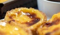 Lots of desserts Pastel de nata or Portuguese egg tart with a white cup of black coffee. Pastel de Belm is a small pie