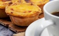 Lots of desserts Pastel de nata or Portuguese egg tart with a white cup of black coffee. Pastel de Belm is a small pie