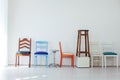 Lots of different chairs in the interior of an empty white room