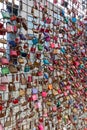 lots of different color padlocks are attached to a wire fence