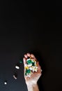 Lots of different medicine drugs, pills, tablets, capsules in woman hand on black matte background.  macro photo with selective Royalty Free Stock Photo