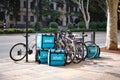 Lots of empty bikes with food delivery boxes outside