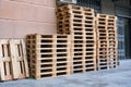 Lots of empty wooden pallets near a store or shopping center on the street