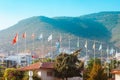 Lots of Europe flags on poles. Mountain in the background and houses nearby