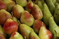 Lots of fresh juicy pears on the market counter. Vitamins, healthy eating and veganism. Close-up Royalty Free Stock Photo