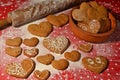 Lots of gingerbread in the shape of a heart on a flour and bowl with cookies