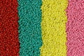 Lots of green, blue, red, yellow, pink granules of polypropylene, polyamide. Chemical products. Plastic, polymers and microplastic