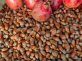 Lots of hazelnuts and pomegranate fruits. Background from unpeeled walnut. Hazelnut pattern. Market stall. Selection of